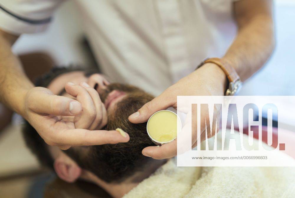 Barber applying cream on beard of a customer MGOF000914