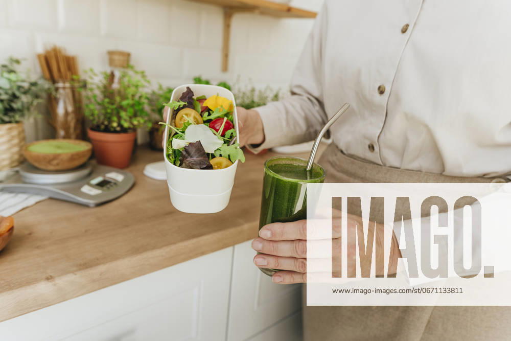 Woman holding salad and detox juice in kitchen at home model released, Symbolfoto property released, YTF00886