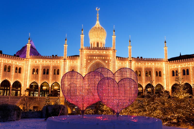 Copenhagen, Denmark - 5 December 2018: Tivoli Gardens amusement park pleasure garden. Twinkling bright lights decorate the, Copenhagen, Denmark - 5 December 2018: Tivoli Gardens amusement park pleasure garden. Twinkling bright lights decorate the buildings and trees in December Christmas time. Holiday background.