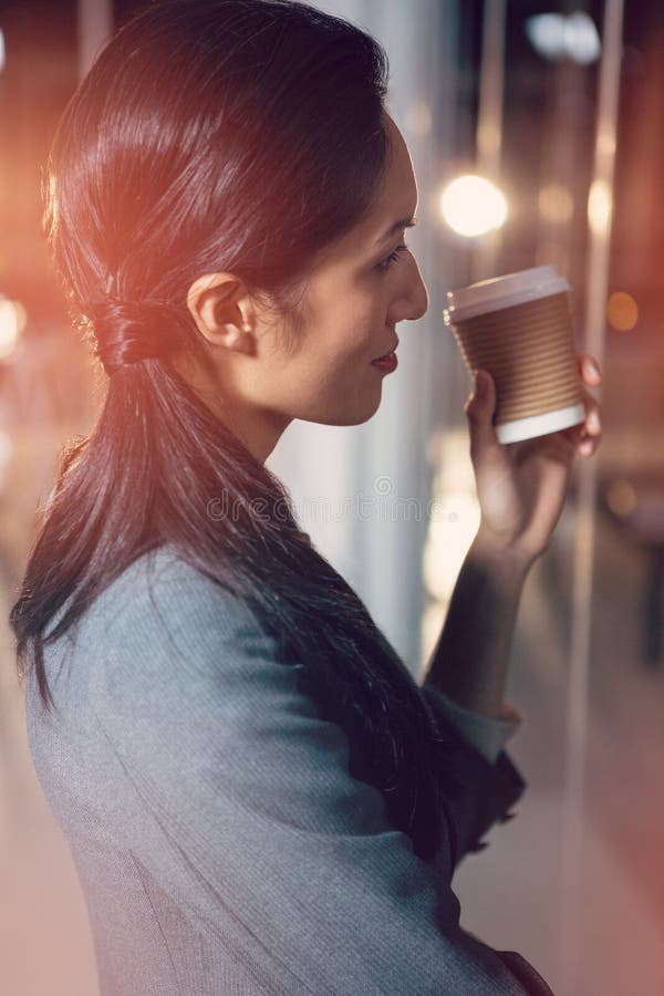 Businesswoman holding disposable coffee cup, Businesswoman holding disposable coffee cup in office model released