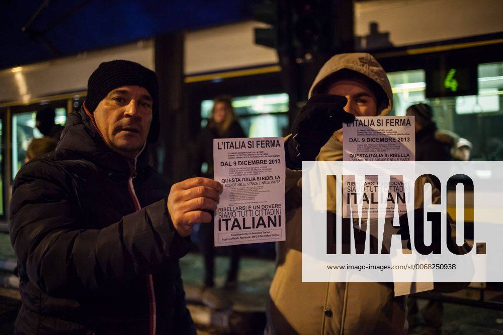 Dec. 9, 2013 - Turin, Italy - Italy in rebellion. People protest in Turin, on December 9, 2013..In photo: Two protesters with the flyer of the day of rebellion...Photo: Cesare Quinto NurPhoto - ZUMAn23