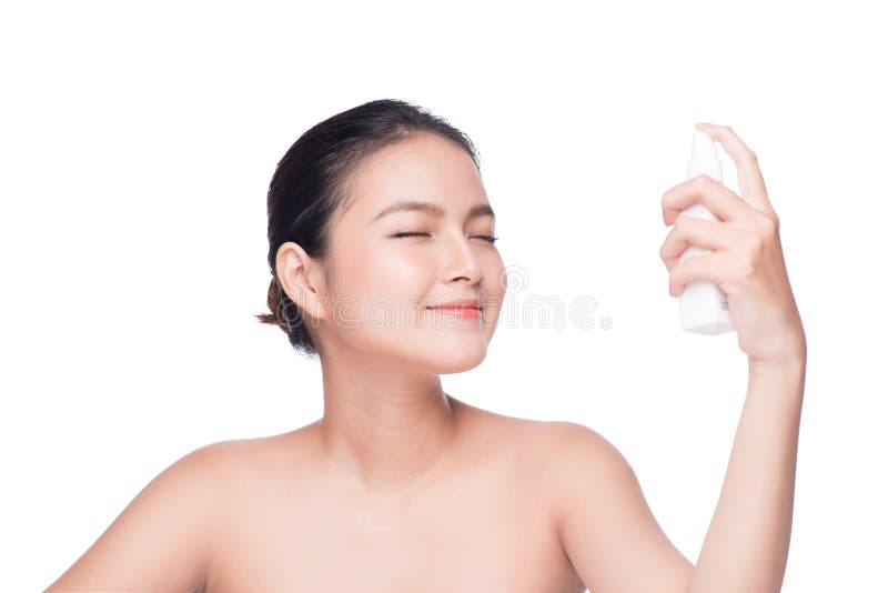 Beautiful asian woman applying spray water on face whit, Beautiful asian woman applying spray water on face white background. model released
