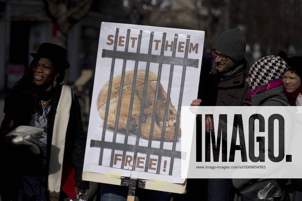 Gedenkmarsch Kolonialgeschichte DEU, Deutschland, Germany, Berlin, 27.02.2016 Demonstranten mit Plakat Voelkermord verjaehrt nicht und Set them Free beim 10. Gedenkmarsch zur Erinnerung an die afrikanischen Opfer von Versklavung, Kolonialismus und rassistischer Gewalt vom Komitee fuer ein afrikanisches Denkmal in Berlin und afrikanischer Vereine in Berlin. Dieser Gedenkmarsch wurde ins Leben gerufen, um der Forderung nach Anerkennung der Verbrechen gegen Schwarze Menschen und Menschen afrikanischer Herkunft Nachdruck zu verleihen. Anlass ist die Berliner Afrika-Konferenz von 1884 - 1885, auf der Afrika vor 130 Jahren unter den europaeischen Kolonialmaechten aufgeteilt wurde. Mehr als 30 Millionen Afrikanerinnen und Afrikaner wurden Opfer von Versklavung und kolonialen Verbrechen gegen die Menschlichkeit. Die von Deutschland an den Herero und Nama begangenen Voelkermorde in Namibia und di
