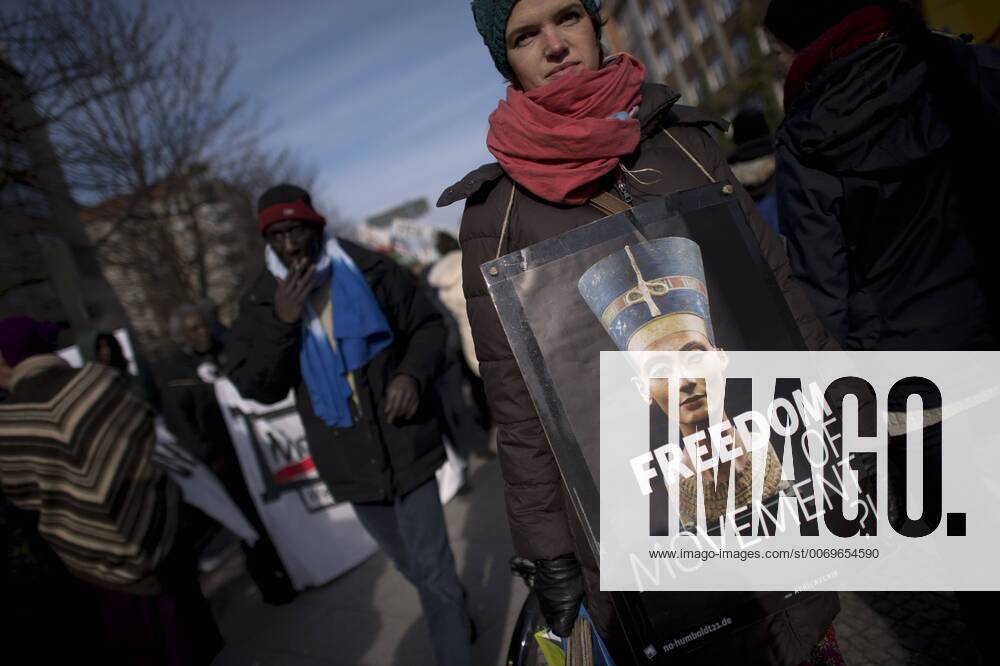 Gedenkmarsch Kolonialgeschichte DEU, Deutschland, Germany, Berlin, 27.02.2016 Demonstrant mit Plakat Freedom of Movement und Foto der Nofretete gegen die Kolobialgeschichte und die Aneigung afrikanischer Kulturgueter durch deutsche Museen und dem Humboldt Forum beim 10. Gedenkmarsch zur Erinnerung an die afrikanischen Opfer von Versklavung, Kolonialismus und rassistischer Gewalt vom Komitee fuer ein afrikanisches Denkmal in Berlin und afrikanischer Vereine in Berlin. Dieser Gedenkmarsch wurde ins Leben gerufen, um der Forderung nach Anerkennung der Verbrechen gegen Schwarze Menschen und Menschen afrikanischer Herkunft Nachdruck zu verleihen. Anlass ist die Berliner Afrika-Konferenz von 1884 - 1885, auf der Afrika vor 130 Jahren unter den europaeischen Kolonialmaechten aufgeteilt wurde. Mehr als 30 Millionen Afrikanerinnen und Afrikaner wurden Opfer von Versklavung und kolonialen Verbrech