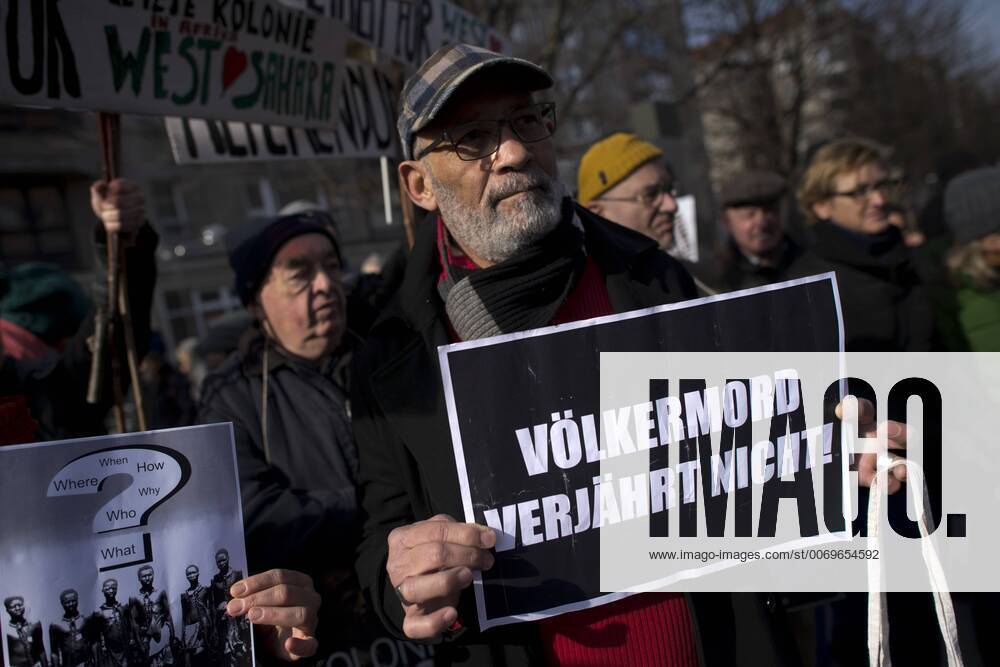Gedenkmarsch Kolonialgeschichte DEU, Deutschland, Germany, Berlin, 27.02.2016 Demonstranten mit Plakat Voelkermord verjaehrt nicht und Set them Free beim 10. Gedenkmarsch zur Erinnerung an die afrikanischen Opfer von Versklavung, Kolonialismus und rassistischer Gewalt vom Komitee fuer ein afrikanisches Denkmal in Berlin und afrikanischer Vereine in Berlin. Dieser Gedenkmarsch wurde ins Leben gerufen, um der Forderung nach Anerkennung der Verbrechen gegen Schwarze Menschen und Menschen afrikanischer Herkunft Nachdruck zu verleihen. Anlass ist die Berliner Afrika-Konferenz von 1884 - 1885, auf der Afrika vor 130 Jahren unter den europaeischen Kolonialmaechten aufgeteilt wurde. Mehr als 30 Millionen Afrikanerinnen und Afrikaner wurden Opfer von Versklavung und kolonialen Verbrechen gegen die Menschlichkeit. Die von Deutschland an den Herero und Nama begangenen Voelkermorde in Namibia und di