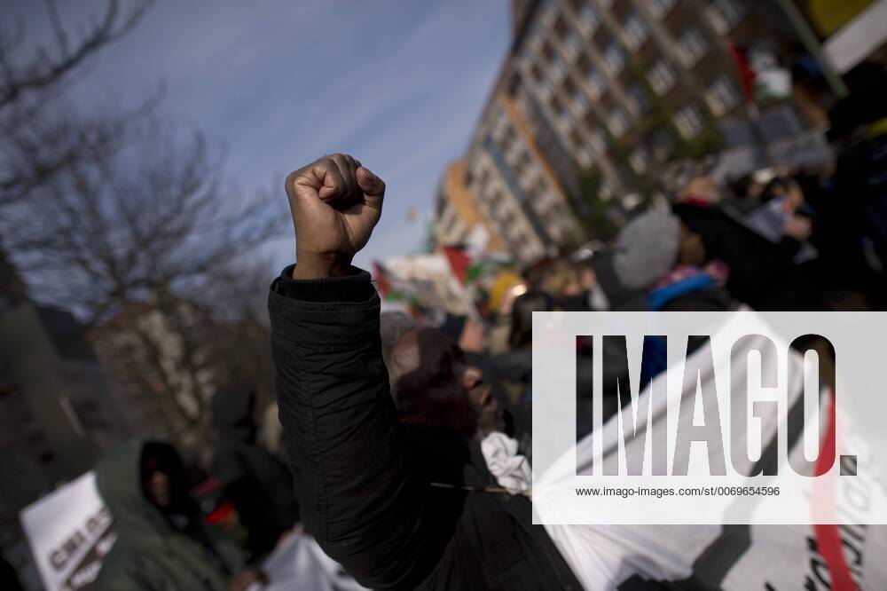 Gedenkmarsch Kolonialgeschichte DEU, Deutschland, Germany, Berlin, 27.02.2016 Demonstranten afrikanischer Herrkunft mit geballter Faust beim Singen der suedafrikanischen Hymne beim 10. Gedenkmarsch zur Erinnerung an die afrikanischen Opfer von Versklavung, Kolonialismus und rassistischer Gewalt vom Komitee fuer ein afrikanisches Denkmal in Berlin und afrikanischer Vereine in Berlin. Dieser Gedenkmarsch wurde ins Leben gerufen, um der Forderung nach Anerkennung der Verbrechen gegen Schwarze Menschen und Menschen afrikanischer Herkunft Nachdruck zu verleihen. Anlass ist die Berliner Afrika-Konferenz von 1884 - 1885, auf der Afrika vor 130 Jahren unter den europaeischen Kolonialmaechten aufgeteilt wurde. Mehr als 30 Millionen Afrikanerinnen und Afrikaner wurden Opfer von Versklavung und kolonialen Verbrechen gegen die Menschlichkeit. Die von Deutschland an den Herero und Nama begangenen Voe