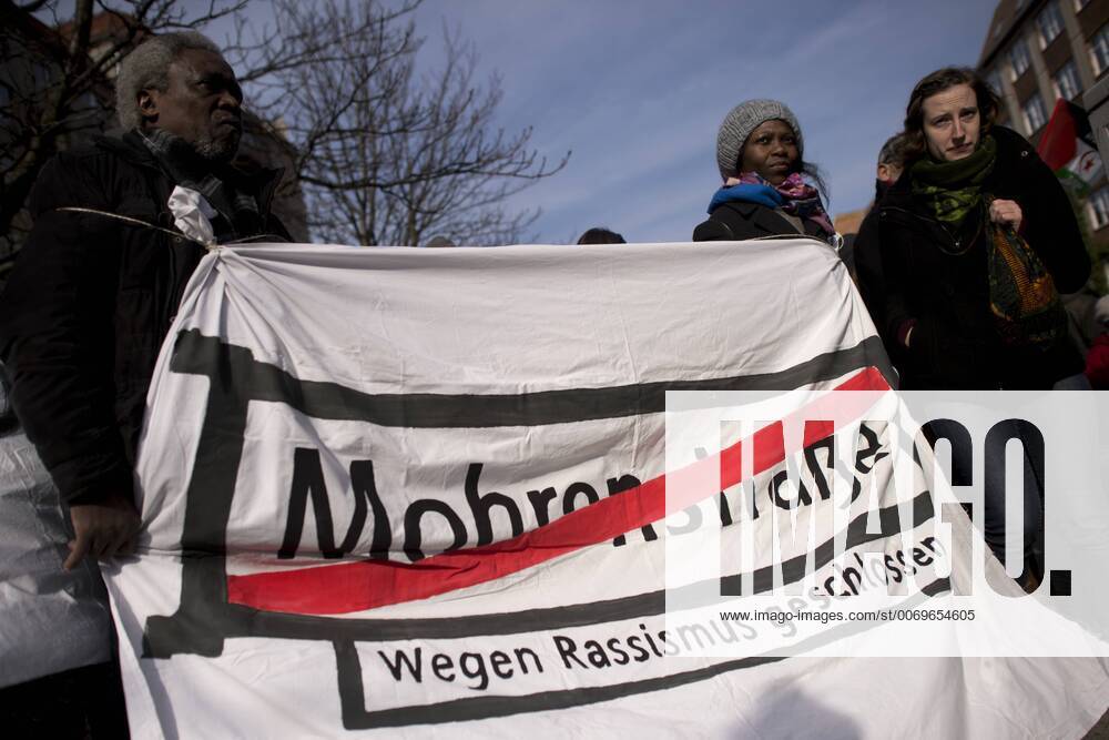 Gedenkmarsch Kolonialgeschichte DEU, Deutschland, Germany, Berlin, 27.02.2016 Demonstranten mitTransparent Mohrenstrasse wegen Rassismus geschlossen fuer die Umbennenung von Strassennamen beim 10. Gedenkmarsch zur Erinnerung an die afrikanischen Opfer von Versklavung, Kolonialismus und rassistischer Gewalt vom Komitee fuer ein afrikanisches Denkmal in Berlin und afrikanischer Vereine in Berlin. Dieser Gedenkmarsch wurde ins Leben gerufen, um der Forderung nach Anerkennung der Verbrechen gegen Schwarze Menschen und Menschen afrikanischer Herkunft Nachdruck zu verleihen. Anlass ist die Berliner Afrika-Konferenz von 1884 - 1885, auf der Afrika vor 130 Jahren unter den europaeischen Kolonialmaechten aufgeteilt wurde. Mehr als 30 Millionen Afrikanerinnen und Afrikaner wurden Opfer von Versklavung und kolonialen Verbrechen gegen die Menschlichkeit. Die von Deutschland an den Herero und Nama be