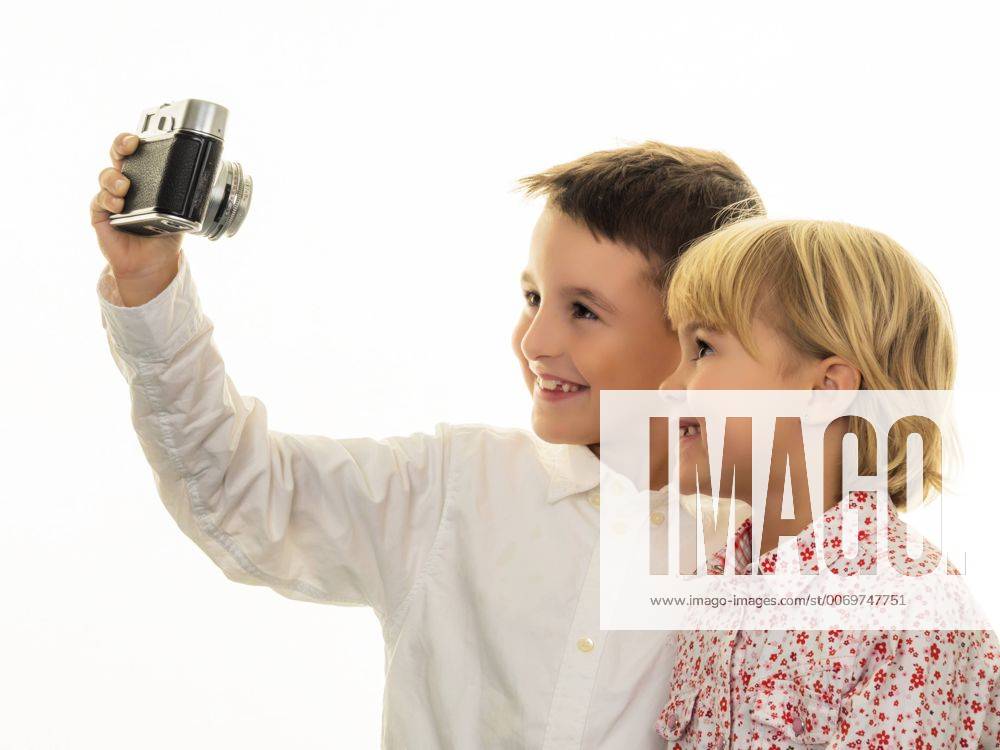 Smiling brother and sister taking a selfie with old-fashioned camera model released Symbolfoto EJWF000769