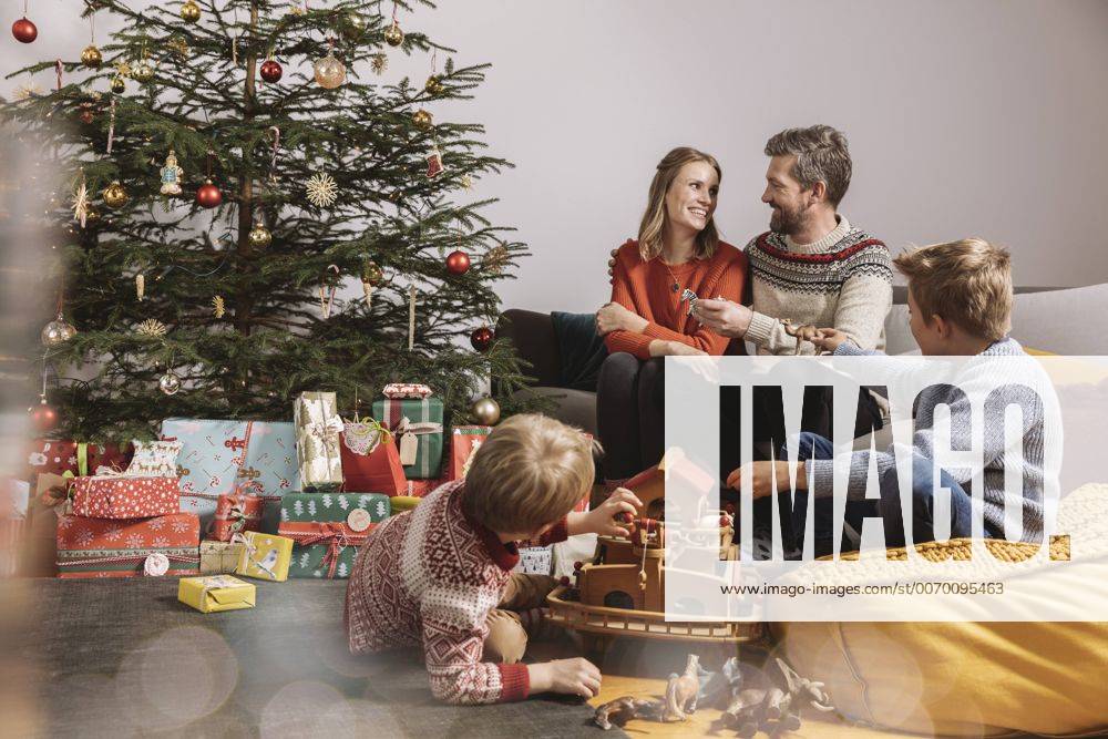 Family of four unwrapping Christmas gifts and playing with Noah s Ark model released Symbolfoto property released MFF002751