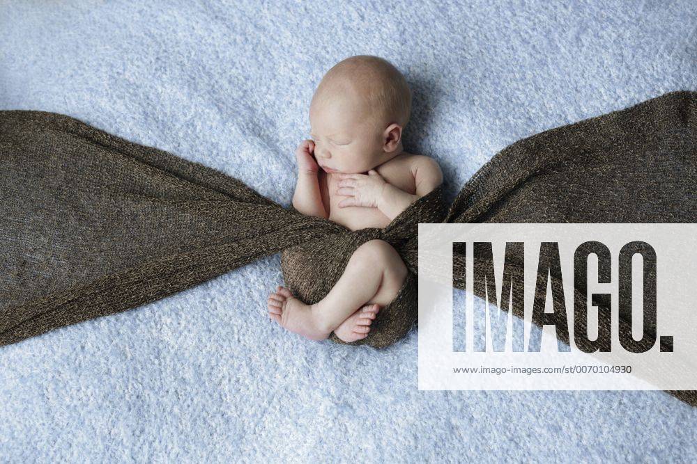 Naked newborn covered with a scarf lying on a blanket model released Symbolfoto SHKF000506