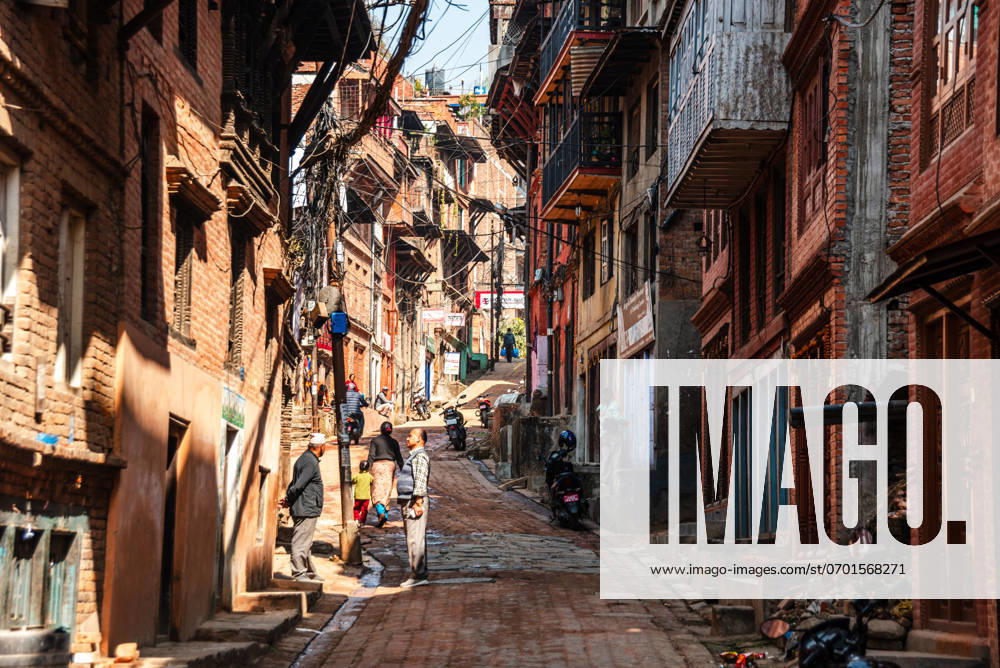 View along a narrow alley road with traditional brick houses in the center of Bhaktapur, Kathmandu, Nepal, Asia