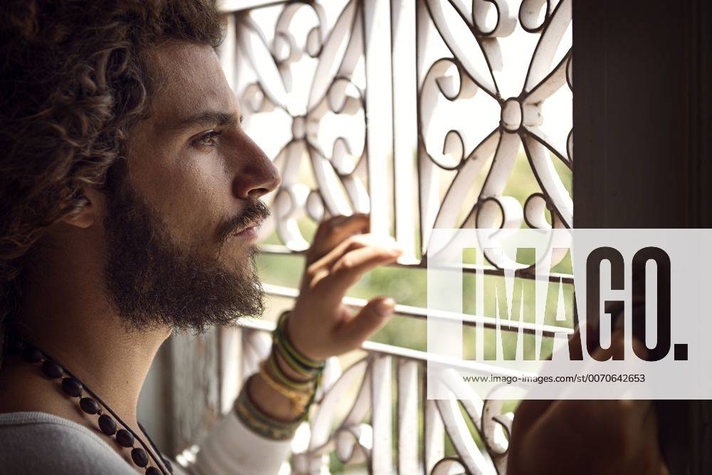 Man standing at window, looking out model released Symbolfoto BMAF000144