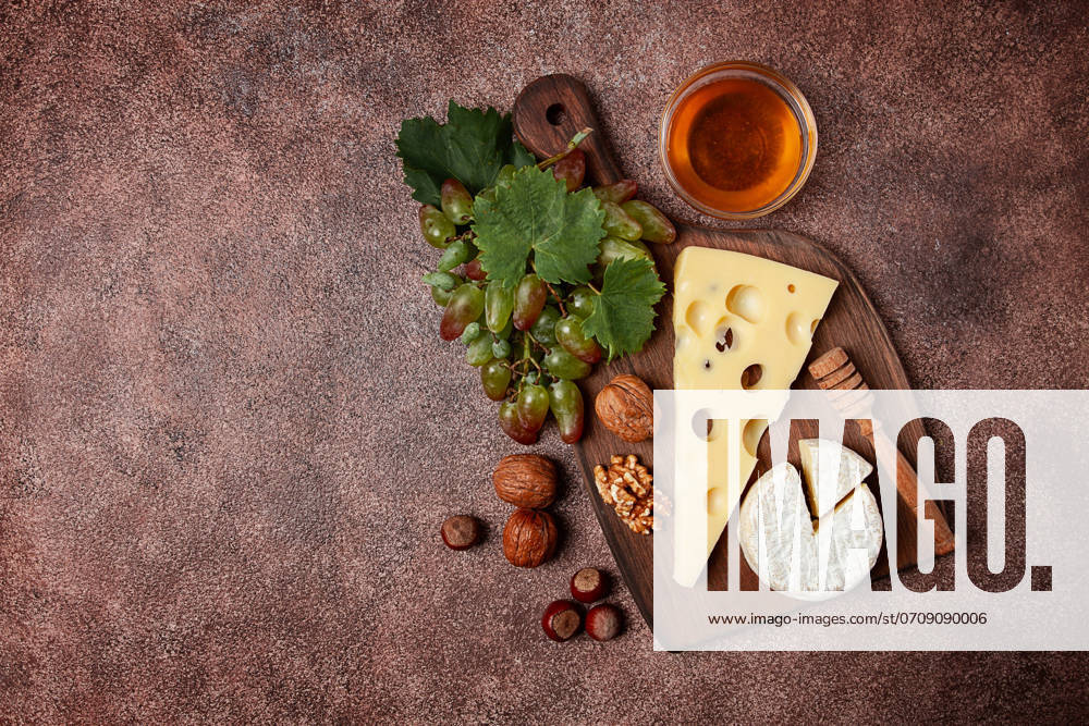 Cheese With Big holes, emmental, maasdam, Brie cheese, ON a Cutting board, With grapes and honey, nuts, appetizer to wine, Top View