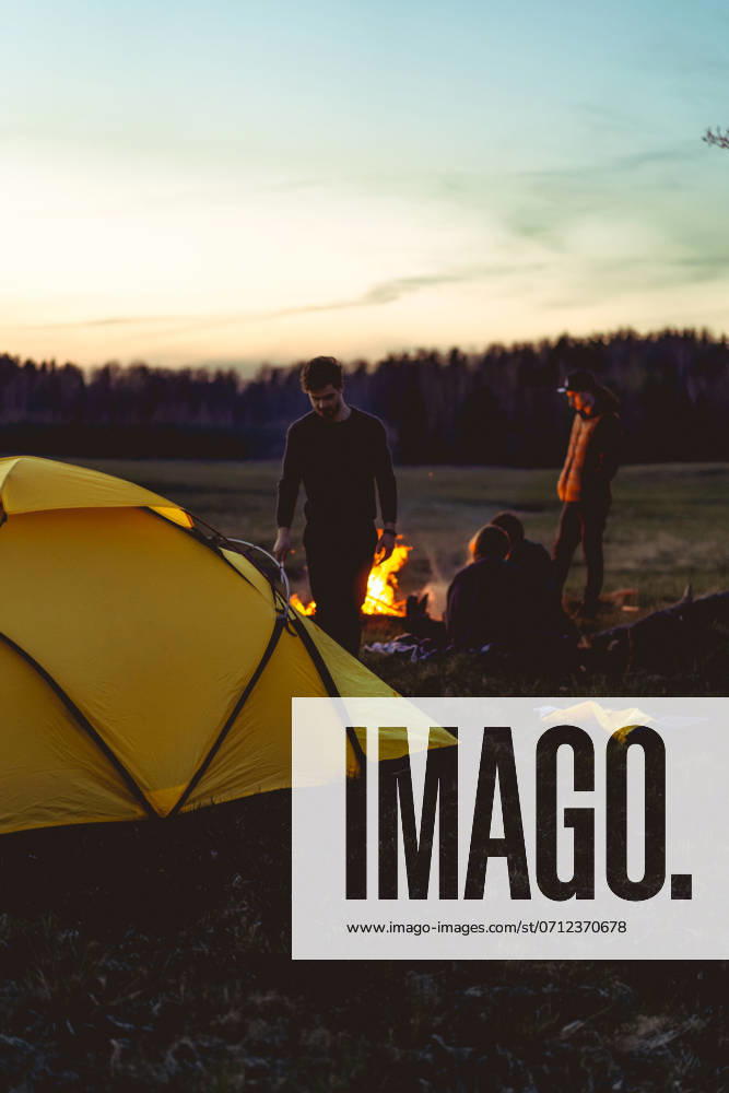 Man sets up a tent on a camping trip, camping sunset tent. Minsk, Minsk Region, Belarus CR_YUKI240612B2-1453857-01 ,model released, Symbolfoto