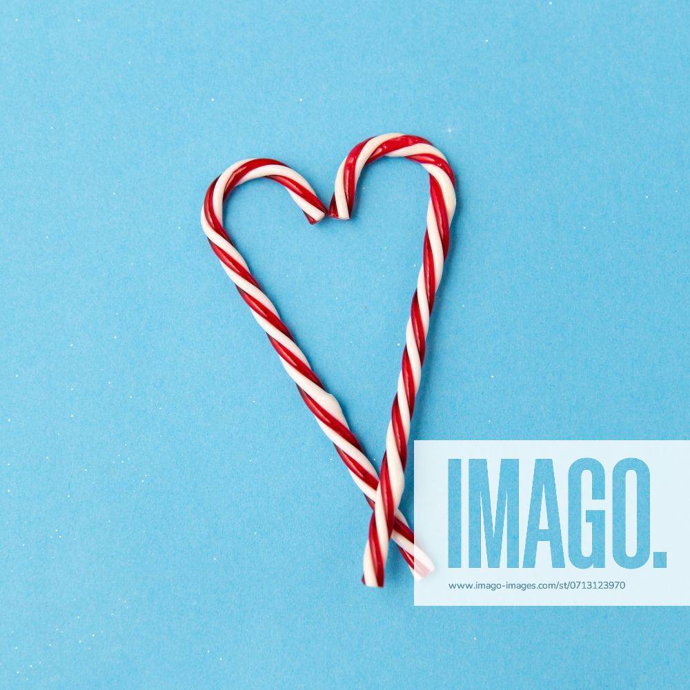 Christmas and winter holidays concept - candy cane decorations in shape of hearts on blue background. candy cane decorations in shape of hearts ,model released, Symbolfoto
