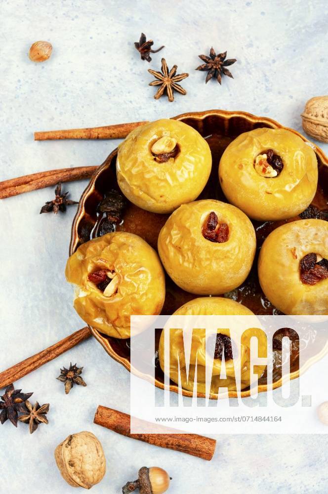 Baked autumn apples with nuts, cinnamon and raisins in plate.. Sweet baked apples. ,model released, Symbolfoto