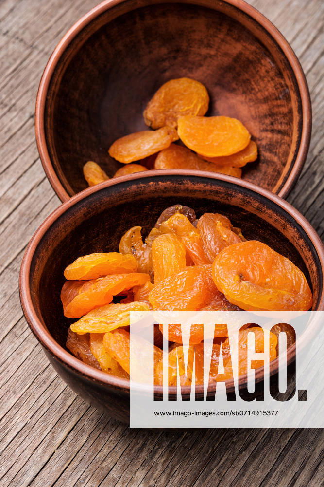 Delicious dried apricots in a bowl.Dried apricots on old wooden table. Heap of dried apricots ,model released, Symbolfoto