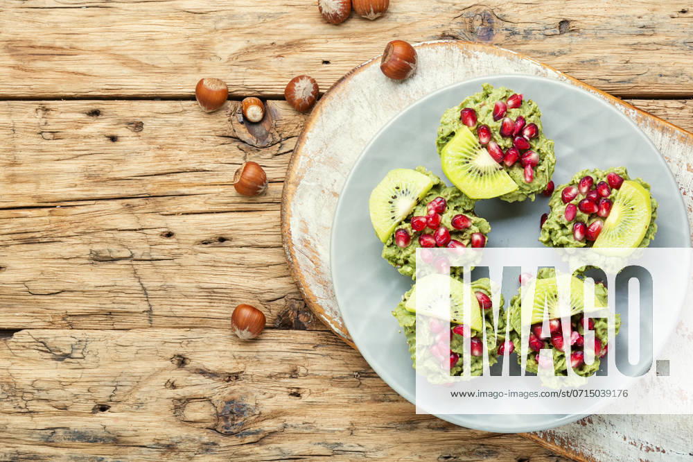 Diet avocado cupcakes garnished with kiwi and pomegranate.Cupcakes on wooden background. Cupcakes from avocado and kiwi. ,model released, Symbolfoto