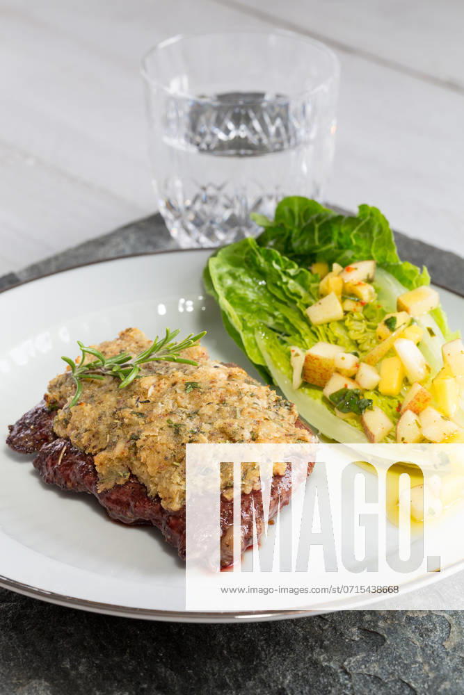 Beef steak with mustard herb crust and romaine lettuce hearts with mango apple vinaigrette.. Beef steak with mustard herb crust and romaine lettuce hearts with mango apple vinaigrette ,model released, Symbolfoto