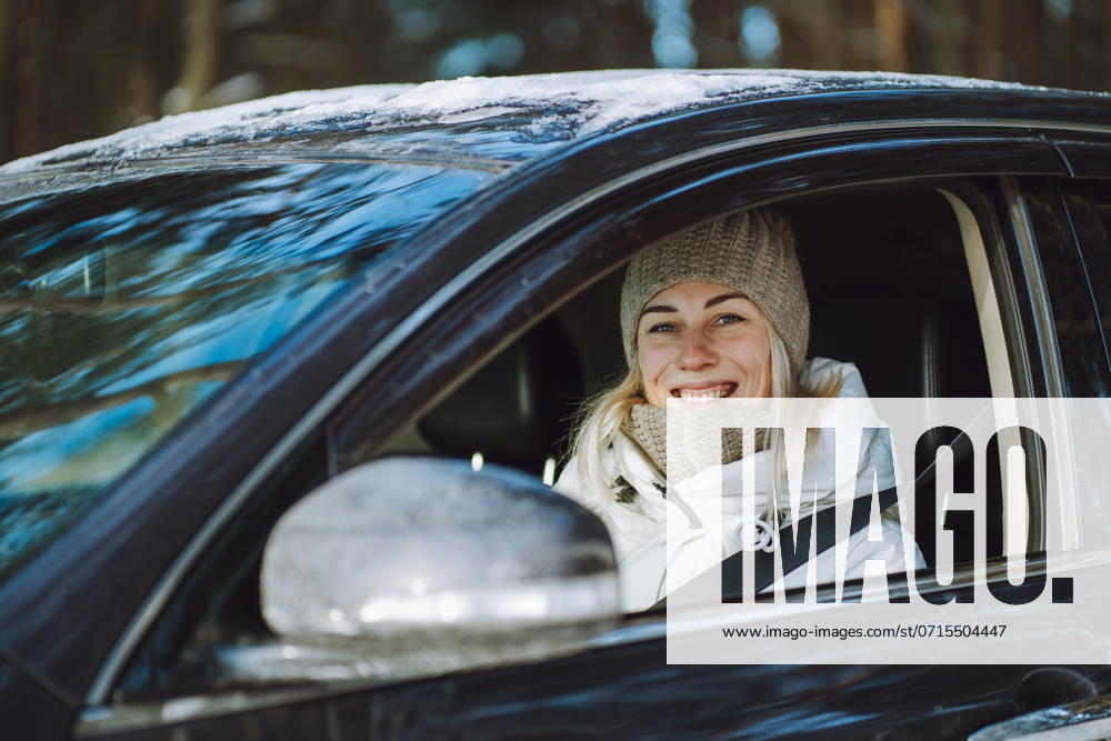 Happy woman wearing warm clothes and sitting in car model released, Symbolfoto, OLRF00345
