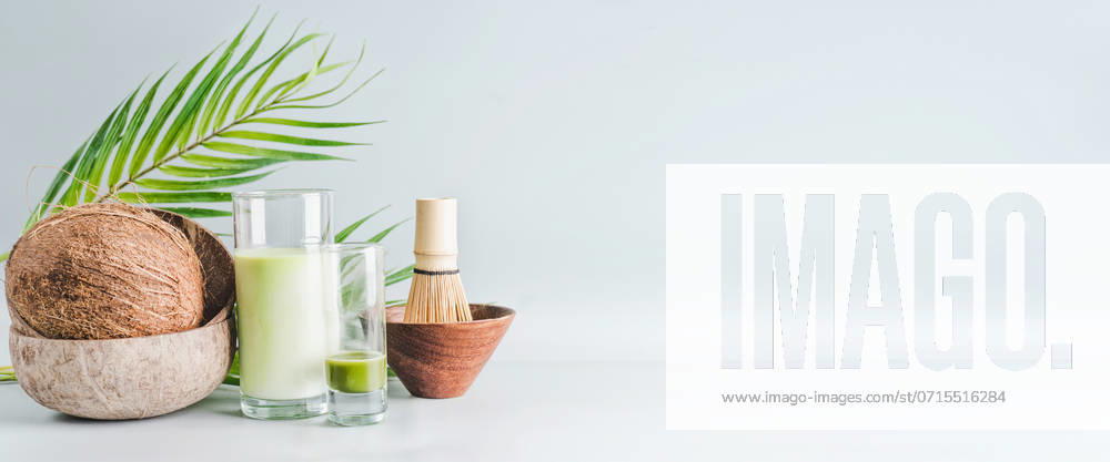 Matcha latte drink with coconut milk on table with whole coconut , matcha espresso and macha whisk, front view, banner. Healthy detox nutrition, vegan food and clean eating concept. Copy space, banner ,model released, Symbolfoto