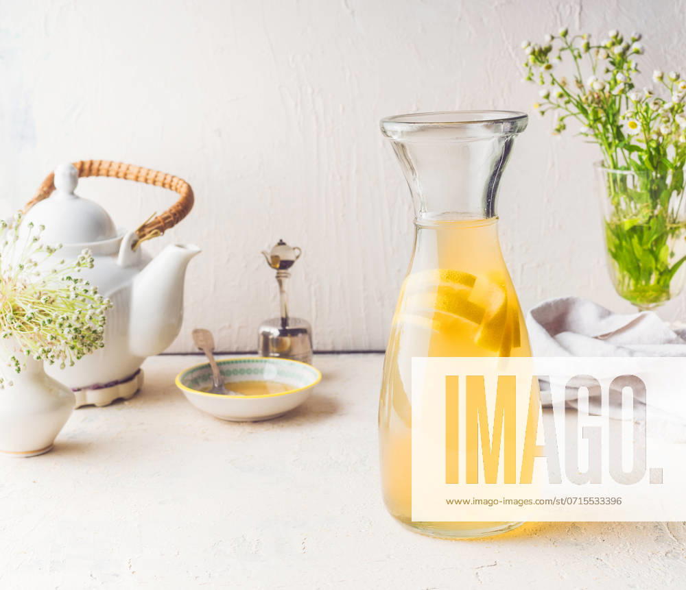 Carafe with white tea citrus lemonade drink on white kitchen table. Summer beverage concept ,model released, Symbolfoto