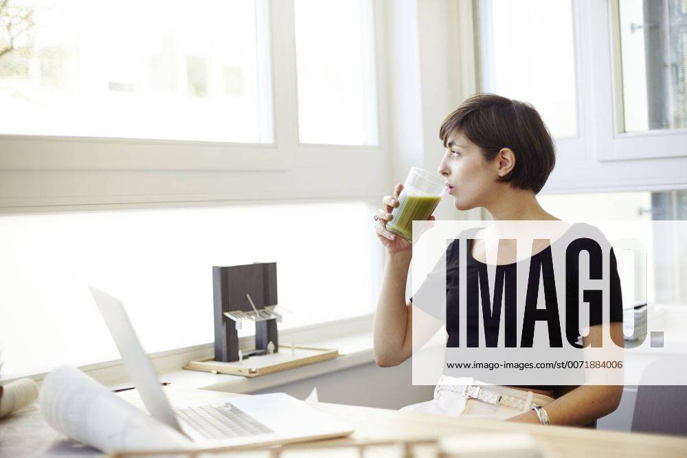 Portrait of woman drinking green smoothie in the office model released Symbolfoto property released TSFF000042