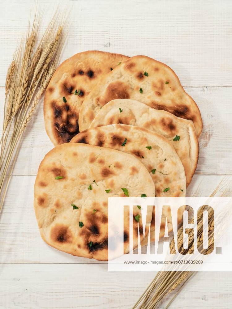 IMAGO Creative, Food, Brot, Naan naan flatbreads on white wood, copy space, top view, Fresh naan bread on white wooden background with copy space. Top view of several perfect naan flatbreads on metal tray. Vertical, Fresh naan bread on white wooden background with copy space. Top view of several perfect naan flatbreads on metal tray. Vertical, 19.07.2023,