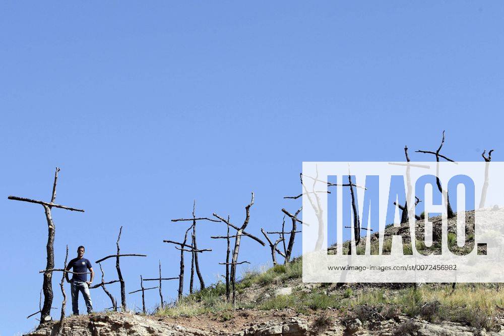 IMAGO Nature: Unsere Erde, Klimawandel, Waldbrände Artist Marc Sellares (L) poses next to his artistic installation in a burnt forest in El Bruc, Barcelona, northeastern Spain, 26 July 2016. The artist began to transform the dead tries in 1,293 crosses one year ago as a mourning ritual . Each cross symbolizes each hectare destroyed. EFE Alberto Estevez Artistic installation in a burnt forest !ACHTUNG: NUR REDAKTIONELLE NUTZUNG! 20160726-636051415365720112