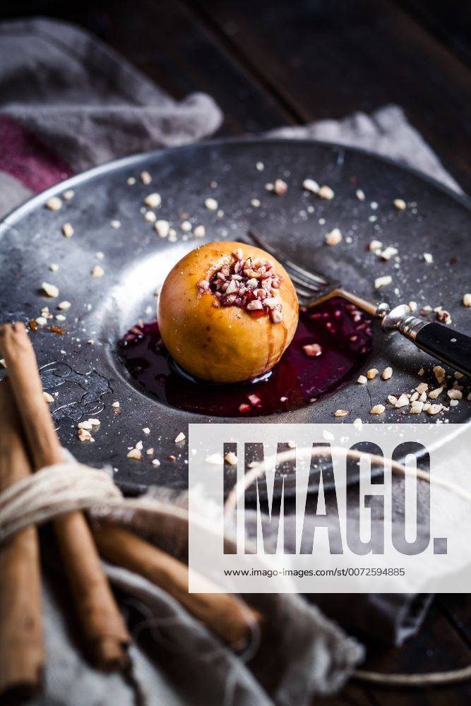 Baked apple with nut- and red jam filling on tin plate SBDF002953