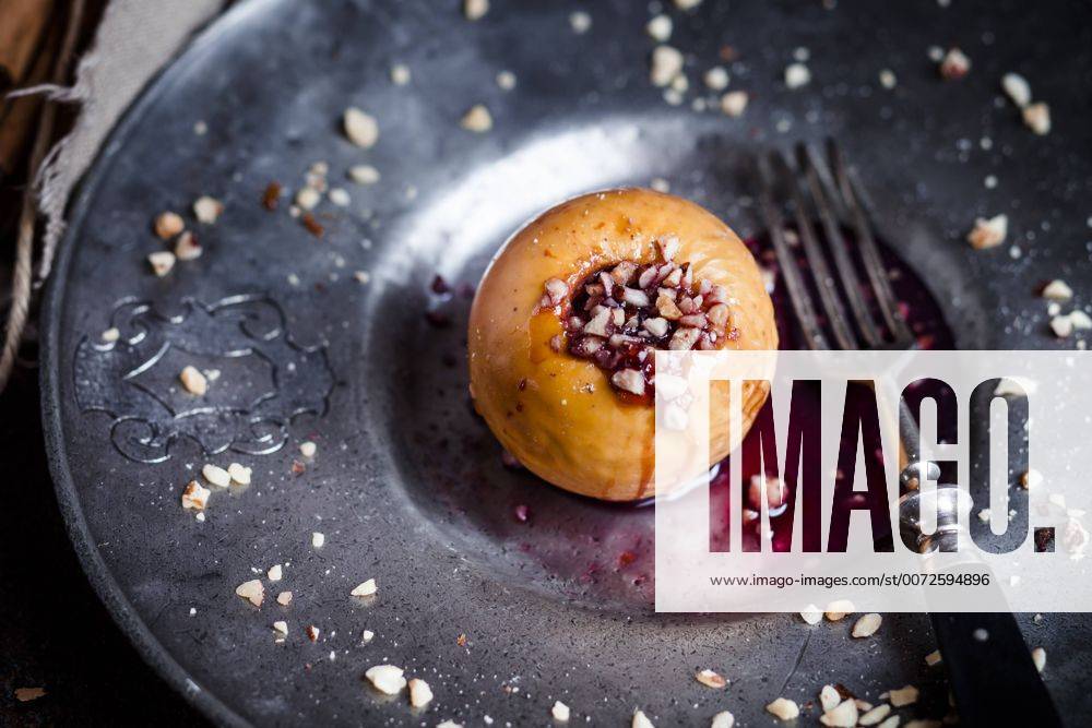 Baked apple with nut- and red jam filling on tin plate SBDF002955