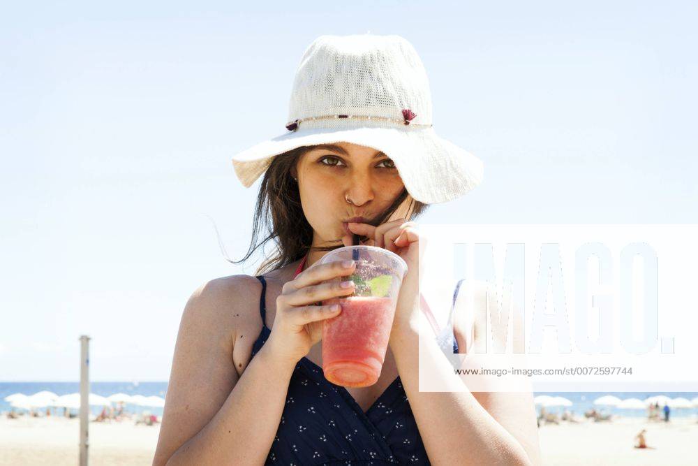 Youniverse - Young Holidays Young woman drinking cocktail on the beach model released Symbolfoto VABF000641
