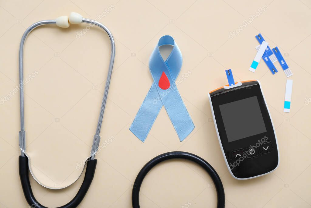 Awareness ribbon with glucometer, strips and stethoscope on beige background. Diabetes concept