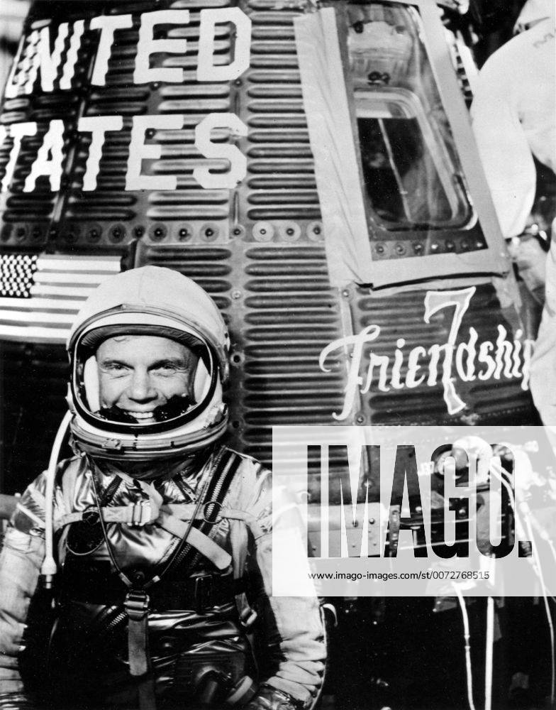 Astronaut John H. Glenn Jr., pilot of the Mercury Atlas 6 (MA-6) spaceflight, poses for a photo with the Mercury Friendship 7 spacecraft during preflight activities.