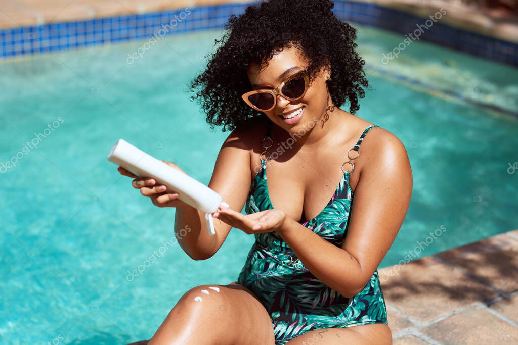 Young beautiful multi-ethnic woman applies sunscreen at the pool summer sun. High quality photo