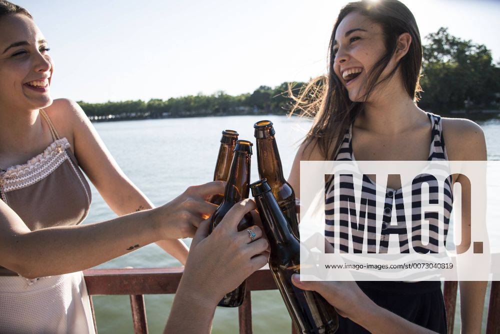 Youniverse - Young Holidays Friends relaxing together at sunlight toasting with beer bottles model released Symbolfoto ABZF000877