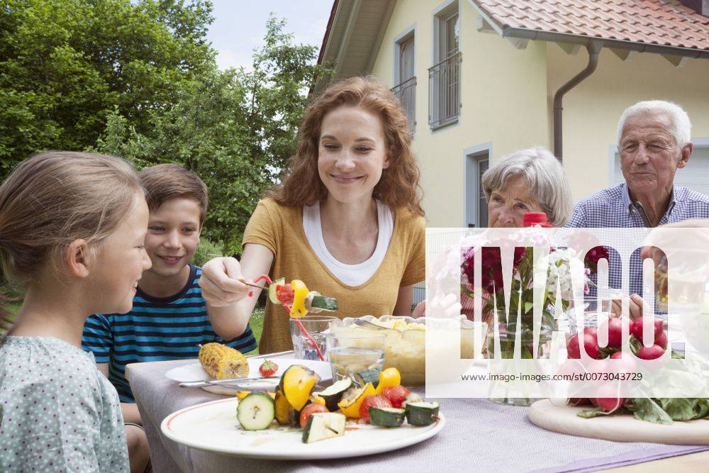 Grillen mit der Familie - Model Released Extended family dining in garden model released Symbolfoto property released RBF004779