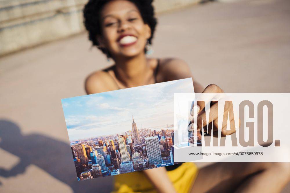Youniverse - Young Holidays Happy woman showing postcard of New York City model released Symbolfoto property released GIOF001429