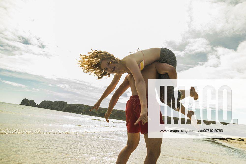 Youniverse - Young Holidays Playful teenage couple on the beach model released Symbolfoto UUF08413