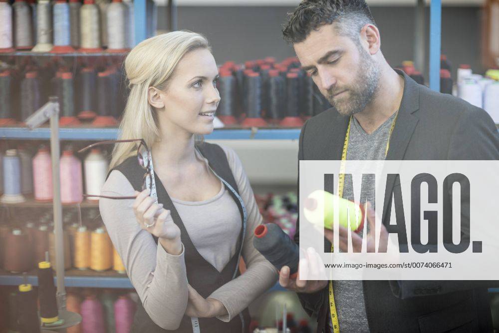 Fashion designer and seamstress examining cotton reels model released Symbolfoto property released ZEF10676