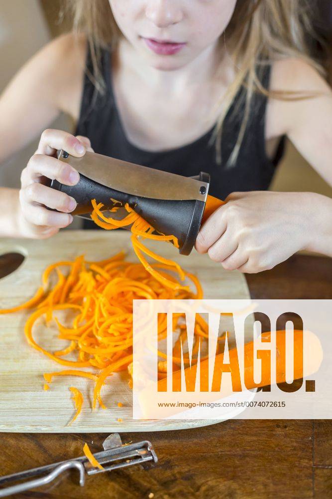Girl using spiral vegetable slicer, partial view model released Symbolfoto SARF03009