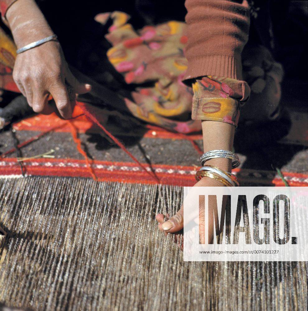 Afghanistan, Shibar Pass. A weaver works on a woolen rug in the Shibar Pass area of Afghanistan.