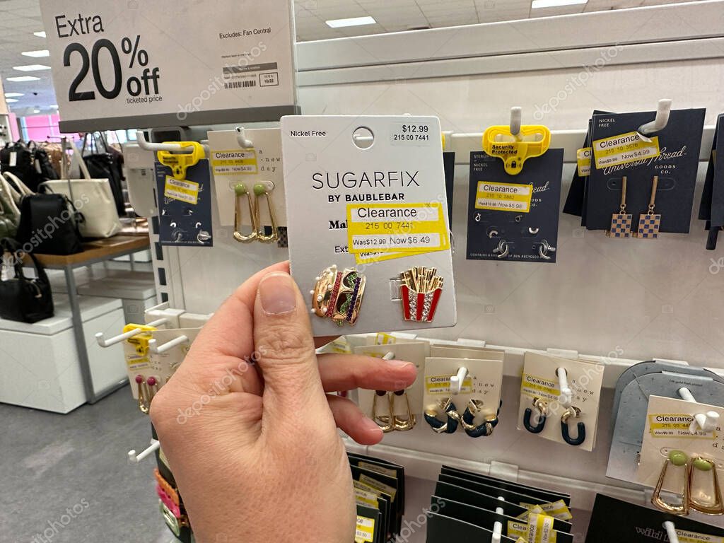 Plymouth, Minnesota - October 22, 2022: Hand holds up a pair of clearance Sugarfix by Baublebar burger and fries earrings for sale