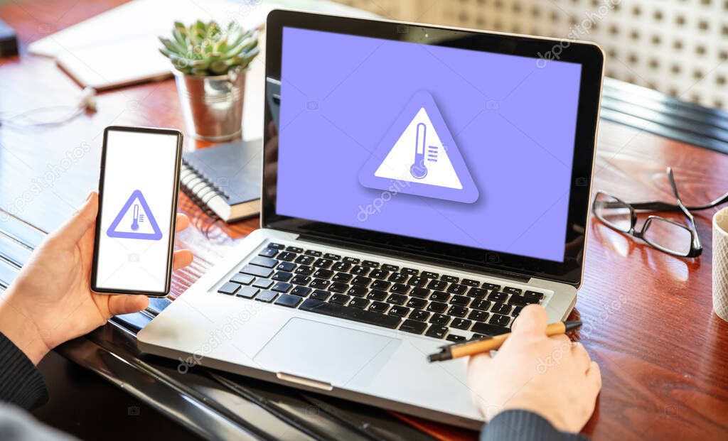 High temperature warning sign on a computer and mobile screen. PC overheat concept. Overload and hot weather danger.