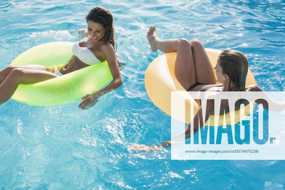 Two young women floating on water in swimming pool model released Symbolfoto MAUF00900