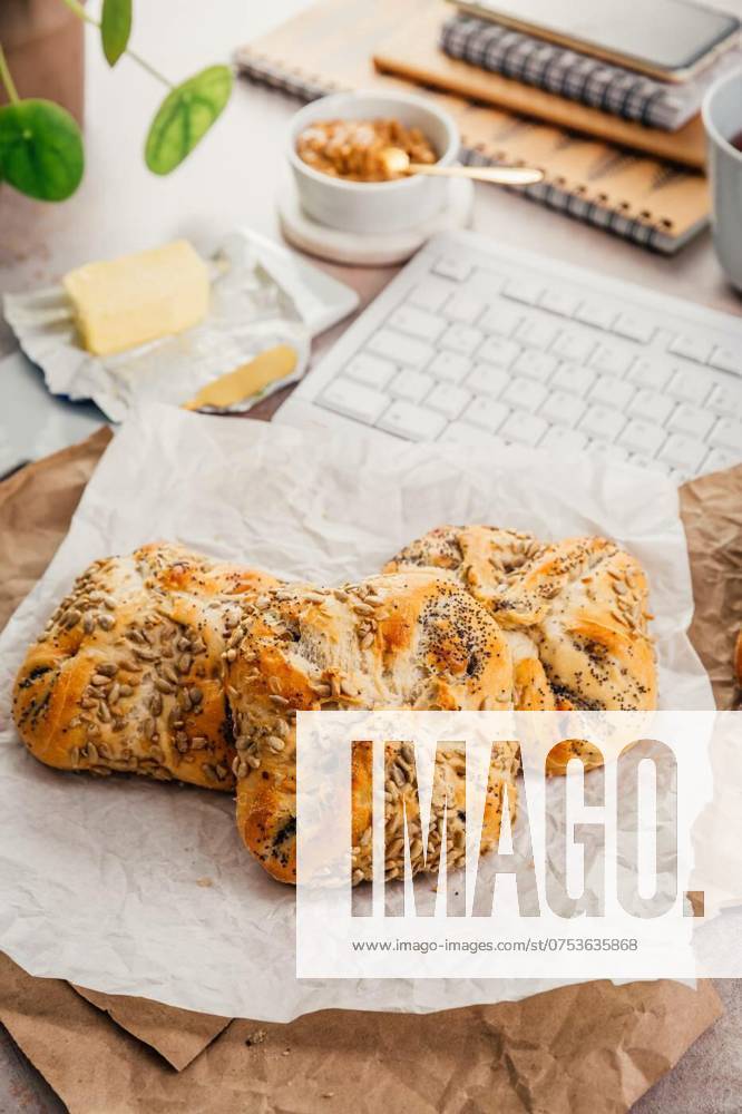 Breakfast at office workplace, fresh bread rolls with butter and cup of tea, Breakfast at office workplace, fresh bread rolls with butter and cup of tea, Breakfast at office workplace, fresh bread rolls with butter and cup of tea, 14.02.2024,