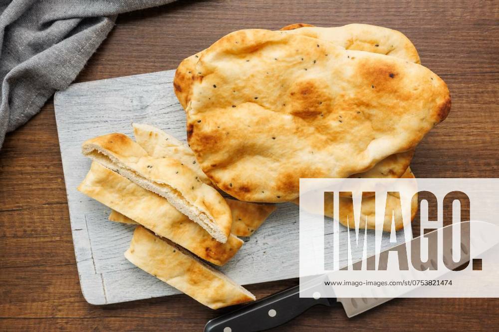 IMAGO Creative, Food, Brot, Naan Freshly Baked Naan Bread on cutting board on wooden table, Freshly Baked Naan Bread on cutting board on a wooden table, Freshly Baked Naan Bread on cutting board on a wooden table, 19.03.2024,