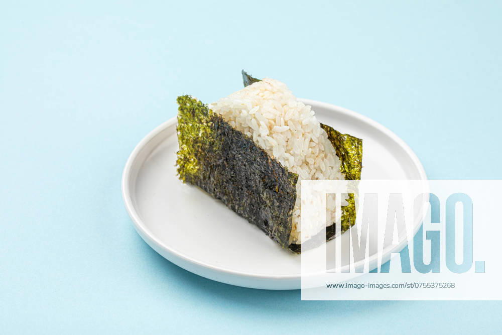 Portion of japanese onigiri snack Portion of japanese onigiri snack on plate on blue background