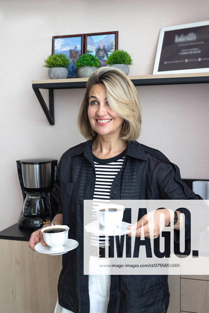 A businesswoman, blonde 45-50 years old, treats customers to bla Nizhegorodets, Nizhny Novgorod Oblast, Russia R_FBQW240805-1502264-01 ,model released, Symbolfoto