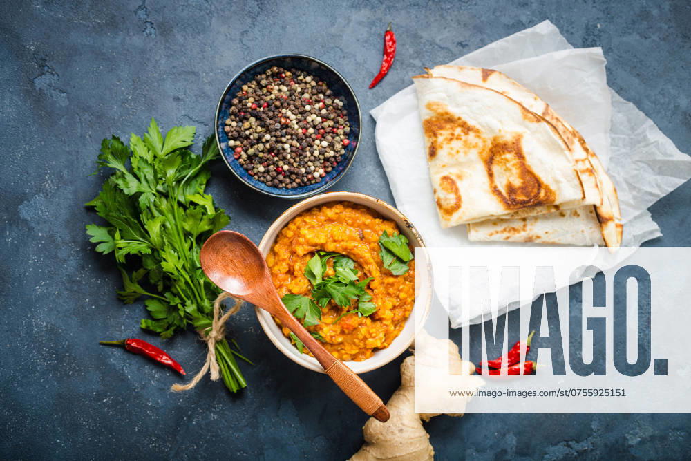 Traditionelle indische Linsen Dal, Naan Butterbrot, frischer Koriander. Indische Dhal würzigen Curry in Schüssel, Gewürze, Kräuter, rustikalen Beton Hintergrund. Ansicht von oben. Indisches Essen. Authentisches indisches Gericht. Draufsicht Traditional Indian lentils Dal, naan butter bread, fresh coriander. Indian Dhal spicy curry in bowl, spices, herbs, rustic concrete background. Top view. Indian food. Authentic Indian dish. Overhead